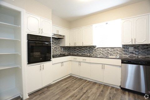 a kitchen with white cabinets and a stainless steel stove and refrigerator